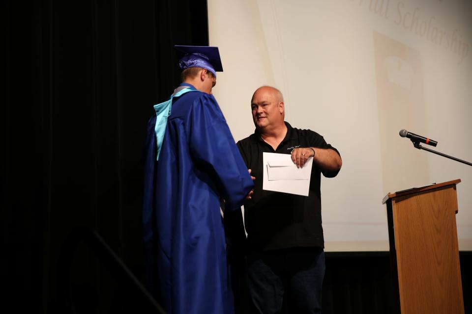 Dave Davis awards a Joshua Davis Memorial Scholarship to Bryce Anliker during the Senior Awards Assembly on Wednesday, May 17, 2023, at Perry Performing Arts Center.