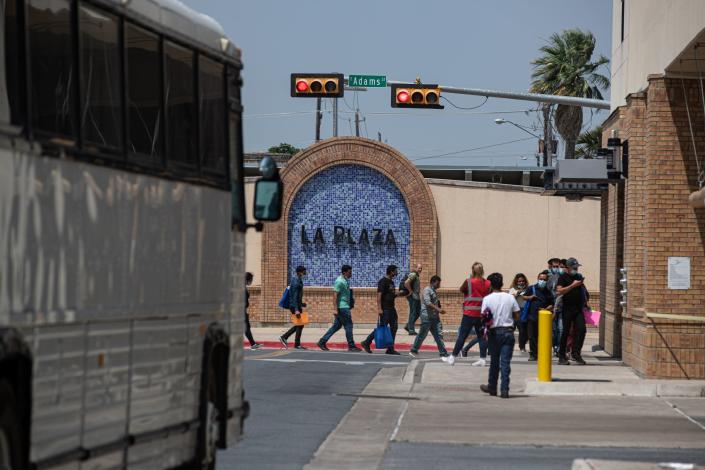 Migrants leave Good Neighbor, a nonprofit, across the street from the migrant intake center at La Plaza bus terminal on May 20, 2022, in Brownsville, Texas. The nonprofit provides food, shoelaces, change of clothing and more essential items to migrants who arrive at the bus terminal.