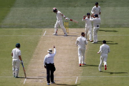 New Zealand's Mark Craig (C) celebrates with team mates as Australia's captain Steve Smith reacts after being dismissed for 53 runs during the second day of the third cricket test match at the Adelaide Oval, in South Australia, November 28, 2015. REUTERS/David Gray