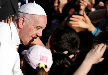 Pope Francis is greeted by a boy as he arrives to visit the Basilica of Saint Bartholomew on the Tiber island in Rome, April 22, 2017. REUTERS/Alessandro Bianchi