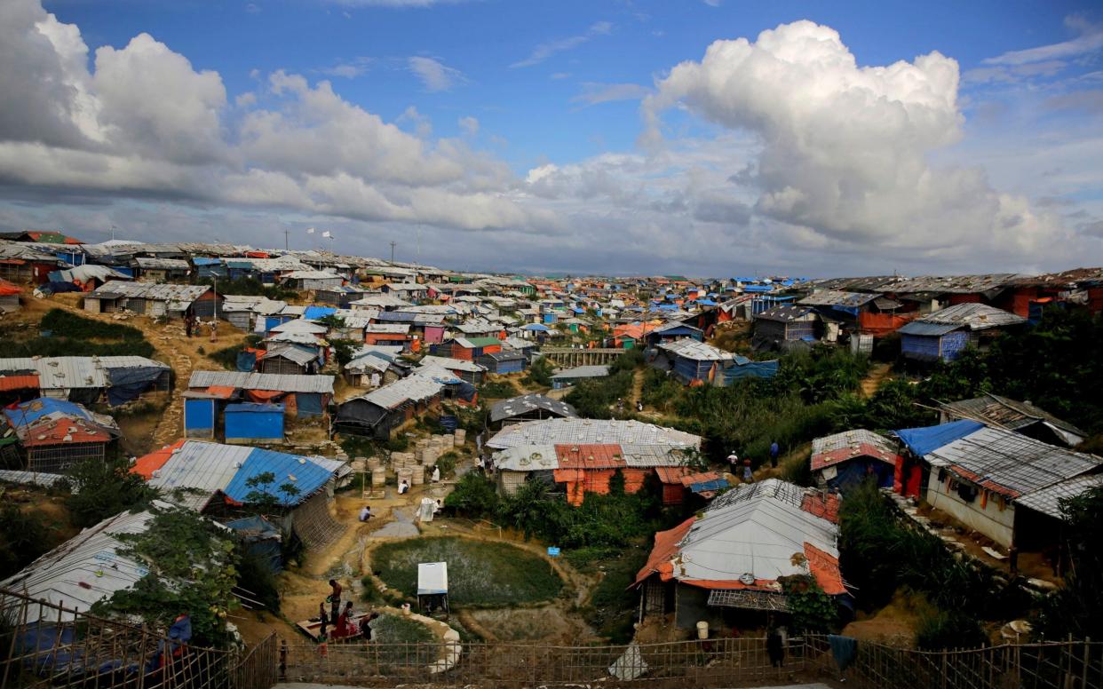 FILE - In this Aug. 26, 2018, file photo, Rohingya refugees bathe at a hand water pump at Kutupalong refugee camp in Bangladesh, where they have been living after feeing violence in Myanmar. A fire in a sprawling Rohingya refugee camp in Bangladesh Thursday, Jan. 14, 2021, has destroyed hundreds of homes. (AP Photo/Altaf Qadri, File) Image title: Bangladesh Rohingya