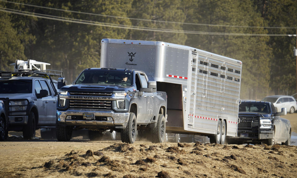 Jason Baldes, from the Eastern Shoshone Tribe, guides his pickup truck with trailer to pick up some of the 35 Denver Mountain Park bison being transferred to representatives of four Native American tribes and one memorial council as they reintroduce the animals to tribal lands Wednesday, March 15, 2023, near Golden, Colo. (AP Photo/David Zalubowski)