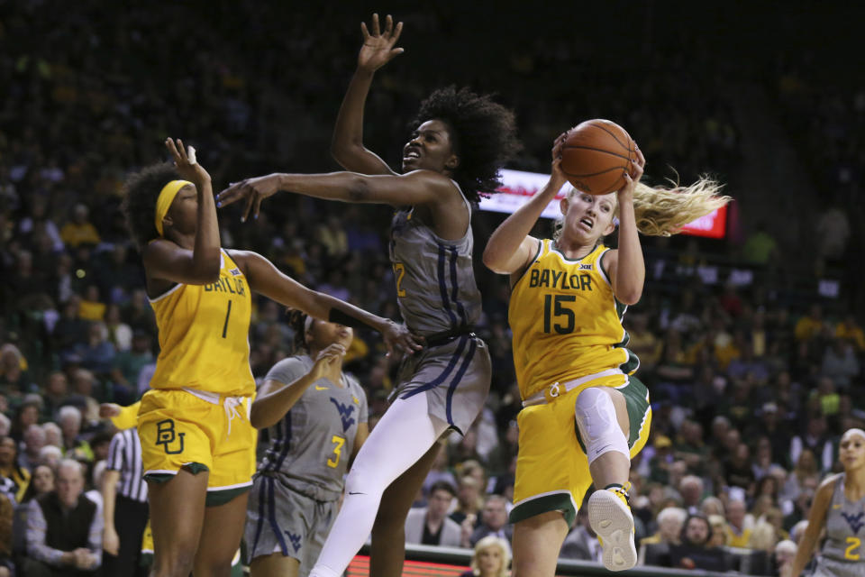 Baylor forward Lauren Cox, right, pulls down a rebound over West Virginia center Blessing Ejiofor, center, in the first half of an NCAA college basketball game, Saturday, Jan. 18, 2020, in Waco, Texas. (AP Photo/Rod Aydelotte)