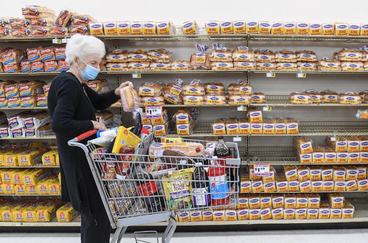 Loretta Pugh of Anderson gets a loaf of bread at Quality Foods in Anderson, S.C. in January 2022.