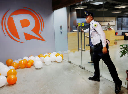 A guard opens a door at the office of Rappler in Pasig, Metro Manila, Philippines January 15, 2018. REUTERS/Dondi Tawatao