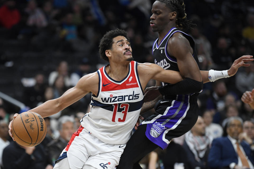 Washington Wizards guard Jordan Poole, left, drives against Sacramento Kings guard Keon Ellis during the second half of an NBA basketball game Thursday, March 21, 2024, in Washington. (AP Photo/John McDonnell)