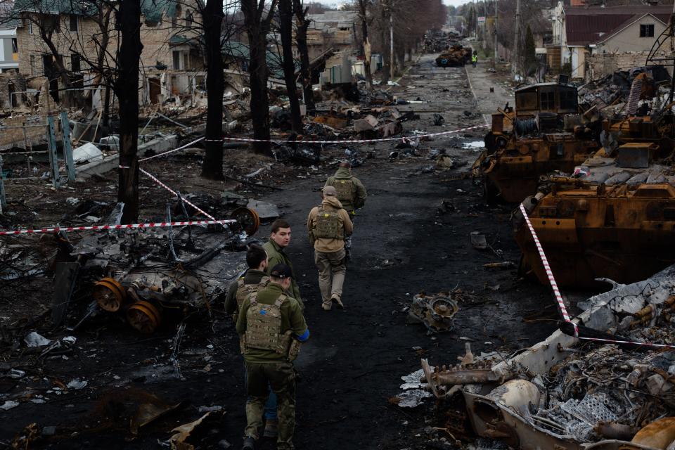 Ukrainian servicemen walk on a destroyed street on April 4, 2022 in Bucha, Ukraine.