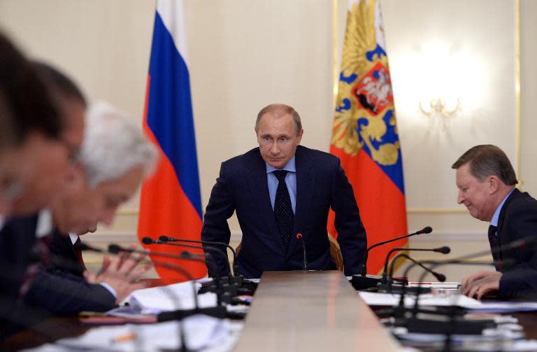 Russian President Vladimir Putin chairs a meeting with members of the government at the Novo-Ogaryovo residence outside Moscow on October 13, 2014