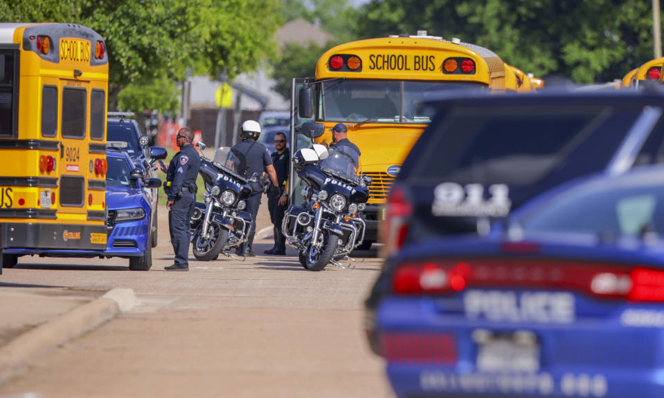 Police officers prepare to escort students to be reunited with their families at Arlington Bowie High School after the school was placed on a lockdown due to a suspected shooting outside the school building, Wednesday April 24, 2024, in Arlington, Texas. (AP Photo/Gareth Patterson)