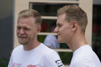 Haas driver Kevin Magnussen, left, of Denmark, stands with Haas driver Mick Schumacher, of Germany, during an interview ahead of the Formula One Miami Grand Prix auto race at Miami International Autodrome, Thursday, May 5, 2022, in Miami Gardens, Fla. (AP Photo/Darron Cummings)