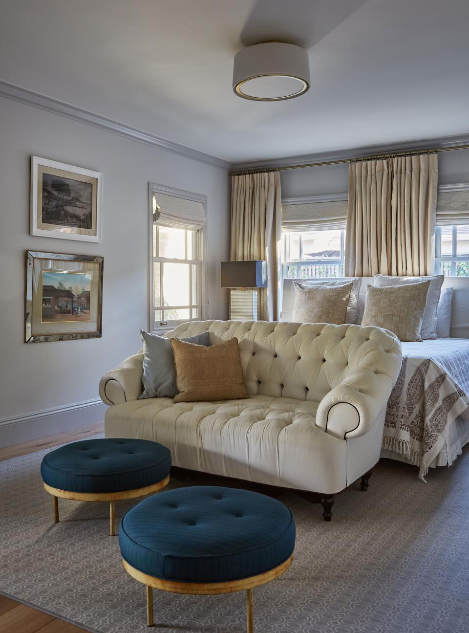 In the master bedroom, a monochromatic palette gives off a peaceful, chill vibe. White linen covers the headboard and settee, and a Les Indiennes blanket adds the cozy. At the end of the bed, two vintage ottomans got a facelift thanks to a layering of Paul Smith suiting fabric. “We’re actually laying on top of our bed, sipping cocktails, talking to you,” jokes Tony before Martel riffs, “and we’re wearing those little nightcaps!”