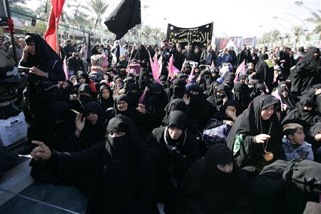 Shi'ite Muslim pilgrims take part in a ceremony to mark the religious ritual of Arbaeen in Kerbala, about 80 km (50 miles) southwest of Baghdad, December 24, 2013. REUTERS/Mushtaq Muhammed