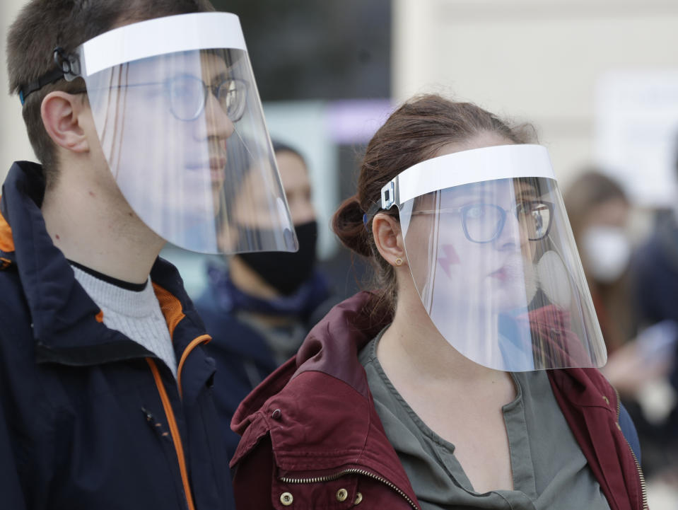 Demonstrators wear protective face masks during a protest a church where they were protesting church support for tightening Poland's already restrictive abortion law in Warsaw, Poland, Sunday, Oct. 25, 2020. Poland constitutional court issued a ruling on Thursday that further restricts abortion rights in Poland, triggering four straight days of protests across Poland.(AP Photo/Czarek Sokolowski)