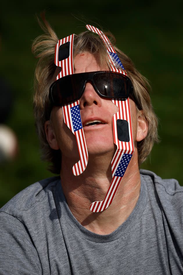 John Fox of Boulder, Colorado, looks at the solar eclipse through two pairs of mylar filter glasses near the base of the Washington Monument on the National Mall on April 08, 2024 in Washington, DC. (Photo by Chip Somodevilla/Getty Images)