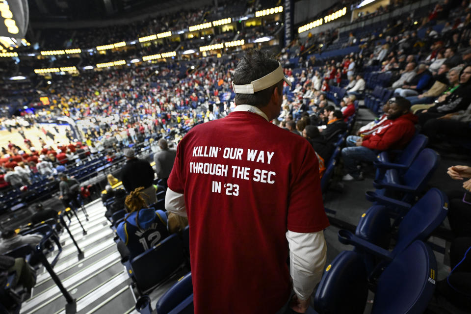 An Alabama fan, who had a T-shirt custom made, takes his seat before an NCAA college basketball game against Missouri in the semifinals of the Southeastern Conference Tournament, Saturday, March 11, 2023, in Nashville, Tenn. (AP Photo/John Amis)