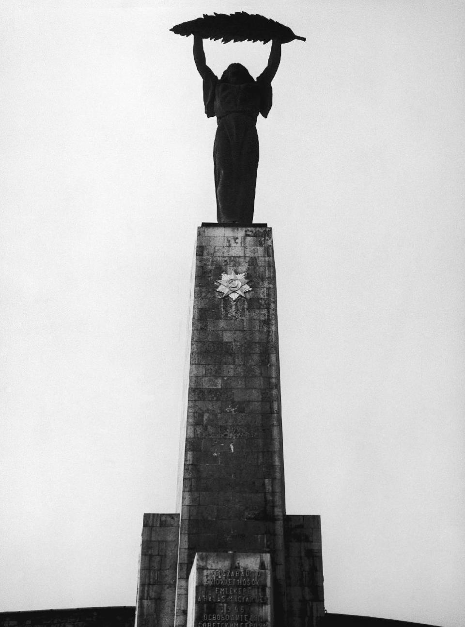 FILE - This Oct. 1957 file photo shows a statue in Budapest, Hungary, by sculptor Zsigmond Kisfaludi Strobl showing a woman holding a palm leaf over her head, was erected in 1947 by the Soviets to commemorate the Nazis' defeat. Budapest’s Liberty Statue at Gellert Hill is a prominent feature of the Buda skyline. But the inscription on the monument has been altered in the years since communism ended in Hungary: Once a tribute to Soviet troops, it’s now a memorial for those who died for Hungary’s freedom. (AP Photo/H. Babout)