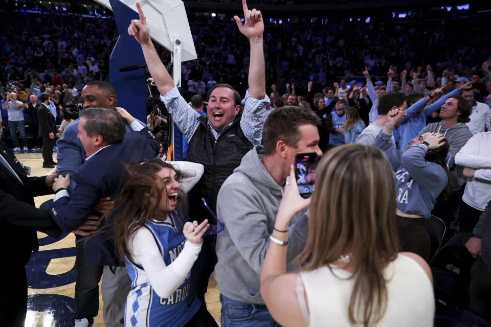 North Carolina fans celebrate as forward Pete Nance (32) tied the score at the close of the second half during an NCAA college basketball game against Ohio State in the CBS Sports Classic, Saturday, Dec. 17, 2022, in New York. The Tar Heels won 89-84 in overtime. (AP Photo/Julia Nikhinson)