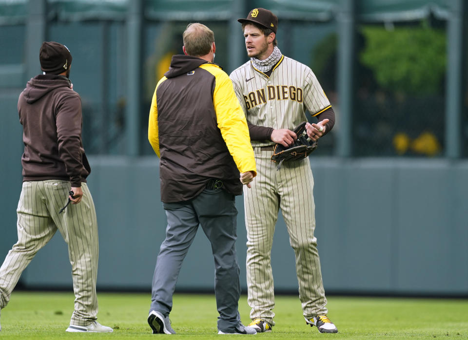 San Diego Padres manager Jayce Tingler, left, and a trainer check on right fielder Wil Myers after he ran into the wall catching a fly ball hit by Colorado Rockies' Garrett Hampson during the first inning of a baseball game Tuesday, May 11, 2021, in Denver. (AP Photo/David Zalubowski)