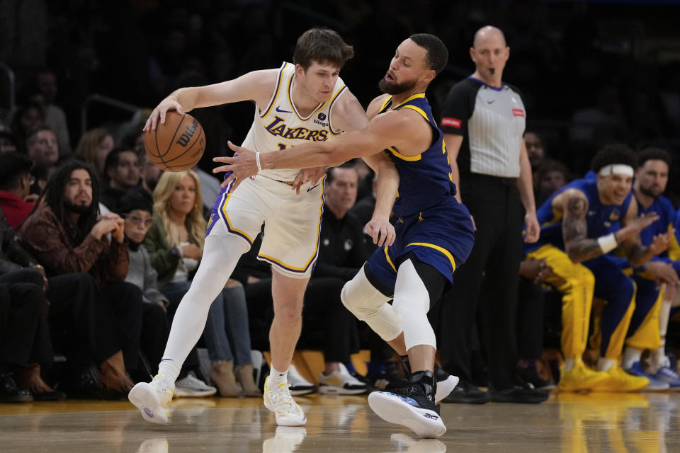 Golden State Warriors guard Stephen Curry, right, defends against Los Angeles Lakers guard Austin Reaves during the first half of an NBA basketball game in Los Angeles, Saturday, March 16, 2024. (AP Photo/Ashley Landis)