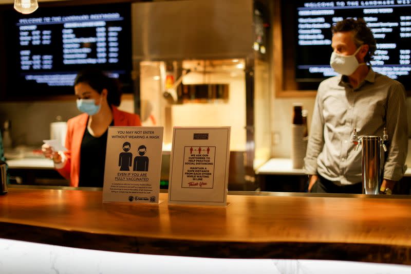 FILE PHOTO: Signs advising about masks and social distancing are pictured by concessions at the Landmark Westwood theatre in Los Angeles