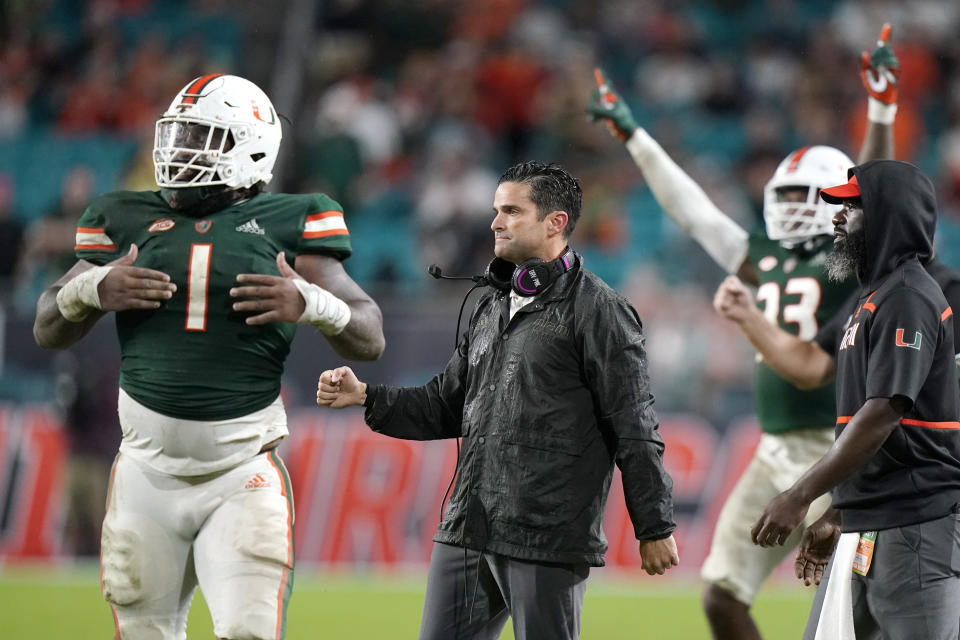 Miami head coach Manny Diaz, center, reacts during the second half of an NCAA college football game against Virginia Tech, Saturday, Nov. 20, 2021, in Miami Gardens, Fla. Miami won 38-26. (AP Photo/Lynne Sladky)