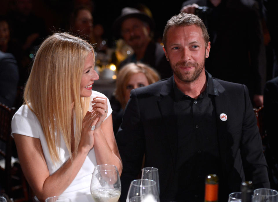 L’histoire d’amour entre Gwyneth Paltrow et Chris Martin débute en 2002. Si les deux personnalités se rapprochent, c’est en grande partie grâce aux rumeurs sur leur supposée relation, qui n’a pourtant pas encore vu le jour. "<em>C’est marrant parce que les gens avaient commencé à l’écrire avant même qu’on sorte ensemble</em>", explique la jeune femme au tabloïd britannique <em>The Sun</em> en 2013, lors de la promotion d’<em>Iron Man 3</em>. Lorsqu’une comédienne qu’il invite à un concert organisé à Los Angeles ne répond pas présent, Chris Martin lance, cité par sa future compagne : "<em>Oh, ça c'est à cause de ma petite amie Gwyneth Paltrow</em>". Une plaisanterie qui ne fait que renforcer les rumeurs autour de leur idylle. Ces dernières éveillent mêmes les soupçons de l’actrice, qui rétorque : "<em>Mais je n’ai jamais rencontré ce mec !"</em> Finalement, les deux stars se rencontrent à la suite d’un concert de Coldplay à Londres, et la magie opère entre eux… Le couple se marie le 5 décembre 2003. <em>(Photo by Kevin Mazur/Getty Images for J/P Haitian Relief Organization)</em>