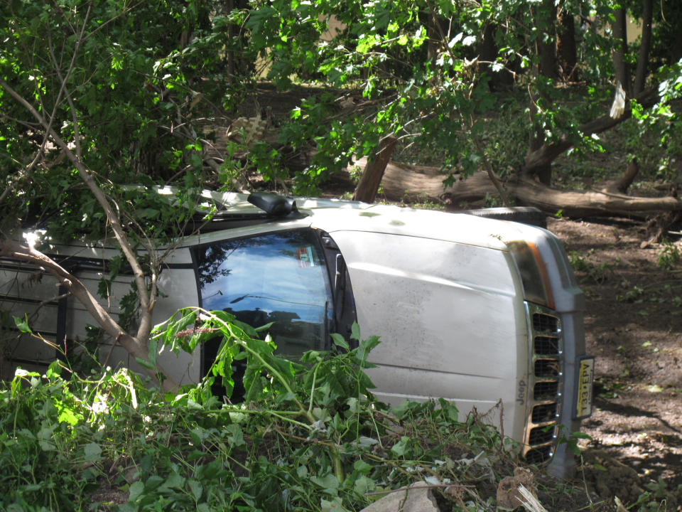 A car that was that was swept onto the banks of the Raritan River by the remnants of Tropical Storm Ida, remains in the area in Piscataway N.J, on Saturday, Sept. 4, 2021. (AP Photo/Wayne Parry)