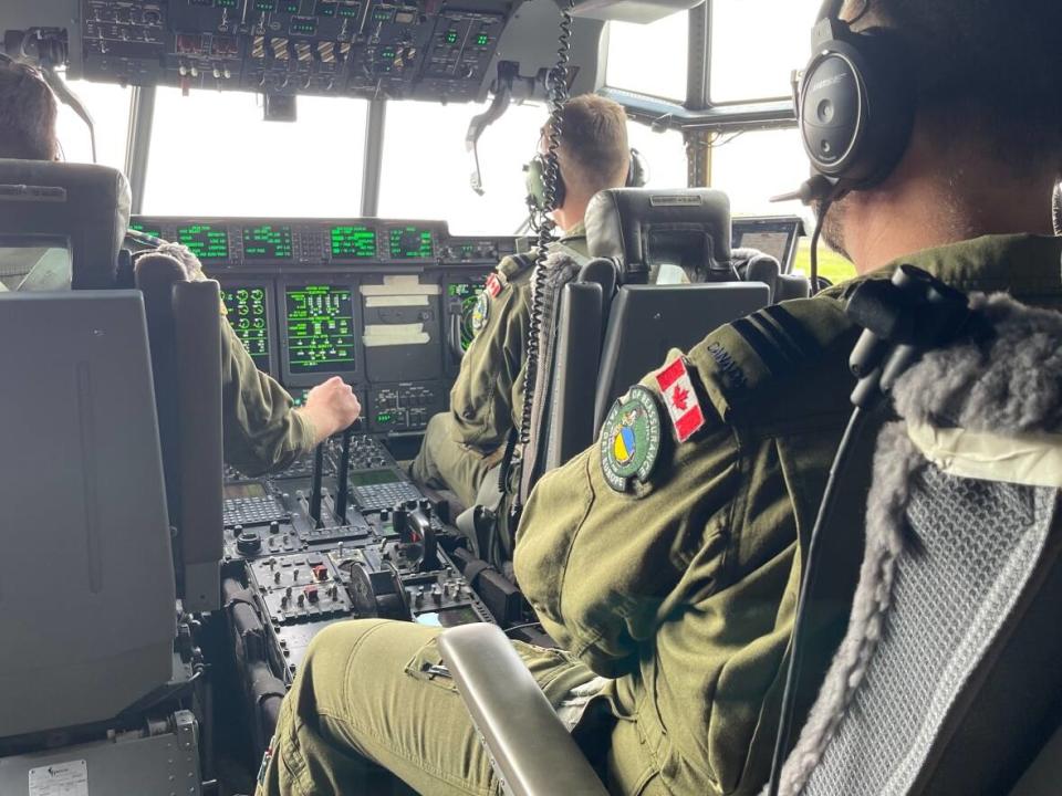 An aircrew from Canadian Forces Base Trenton's 8 Wing pilot a C130-J Hercules aircraft to Poland from Prestwick, Scotland, for the next part of a journey transporting aid to Ukraine. (Chris Brown/CBC - image credit)