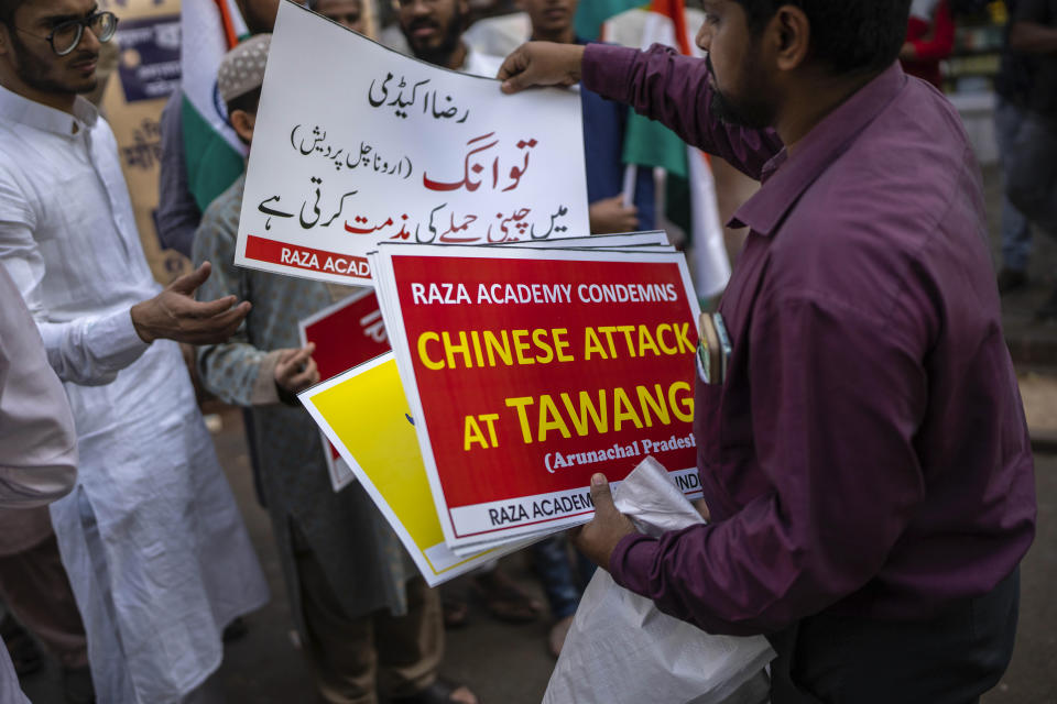 A member of Indian Islamist group Raza Academy distributes placards ahead of a protest against China in Mumbai, India, Tuesday, Dec. 13, 2022. Soldiers from India and China clashed last week along their disputed border, India's defense minister said Tuesday, in the latest violence along the contested frontier since June 2020, when troops from both countries engaged in a deadly brawl. (AP Photo/Rafiq Maqbool)