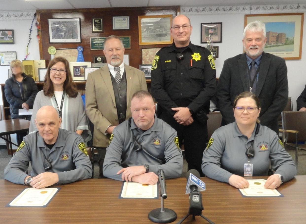 The three security officers hired a year ago, in January 2022 and assigned to the guard the public entrances to the Wayne County Courthouse, Dimmick Building and Park Street Complex, were honored January 29 by the county commissioners. From left, seated are Charles Shelp, Christopher Morris and Justyna Latek. Standing: Commissioners Jocelyn Cramer and Brian Smith; Sheriff Christopher Rosler and Commissioner James Shook.