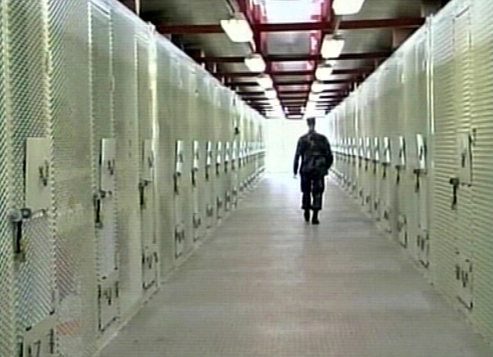 A frame grab taken from undated video footage, released by the U.S. Department of Defence February 5, 2004, shows a U.S soldier patrolling a maximum security area at the military detention facility at the U.S naval base at Guantanamo Bay, Cuba. (REUTERS/DOD Handout )