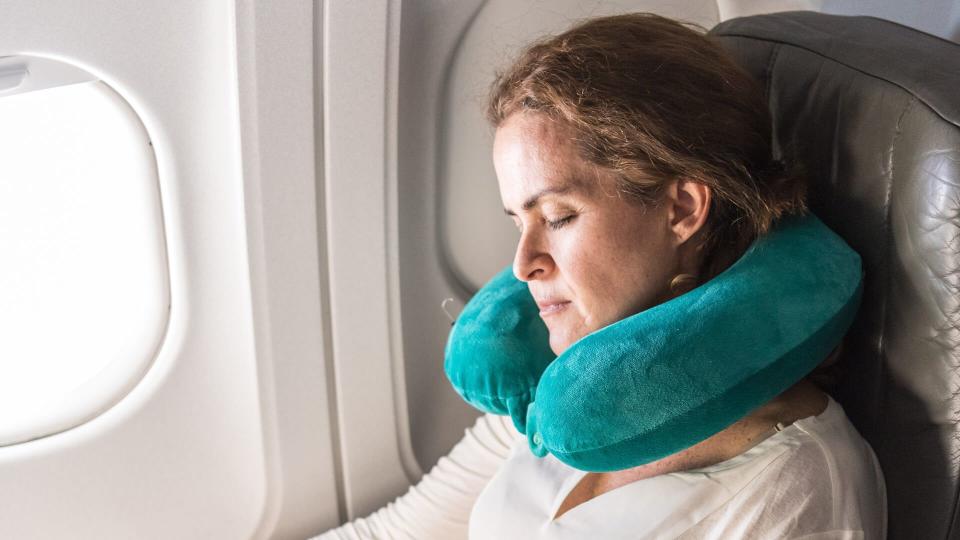 woman sitting inside an airplane sleeping