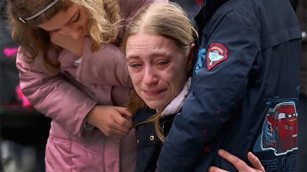 Two children comfort their heartbroken mother as she attends a vigil in Brussels. Photo:  Getty Images