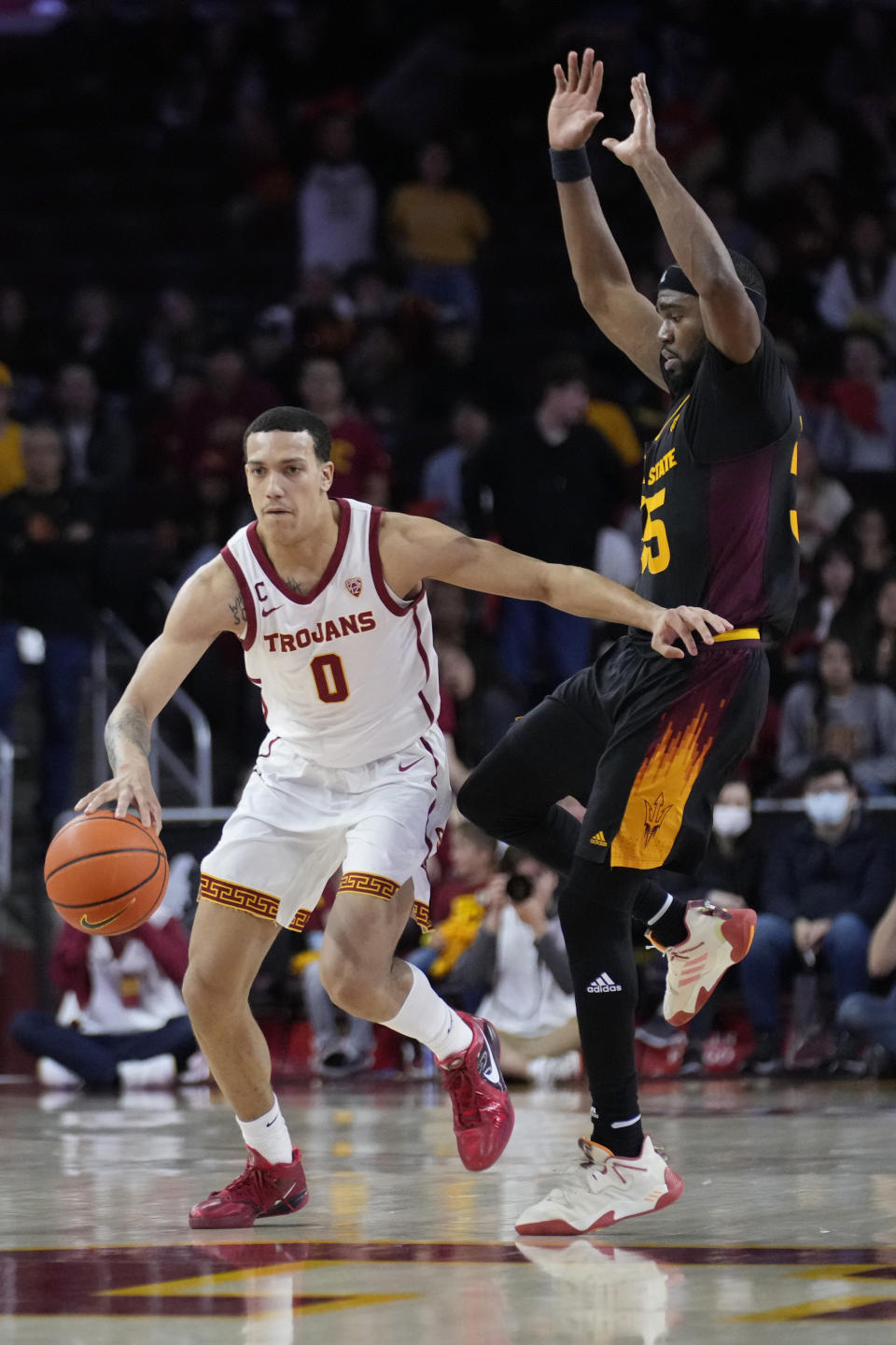 Southern California forward Kobe Johnson (0) dribbles the ball next to Arizona State guard Devan Cambridge during the second half of an NCAA college basketball game Saturday, March 4, 2023, in Los Angeles. (AP Photo/Marcio Jose Sanchez)