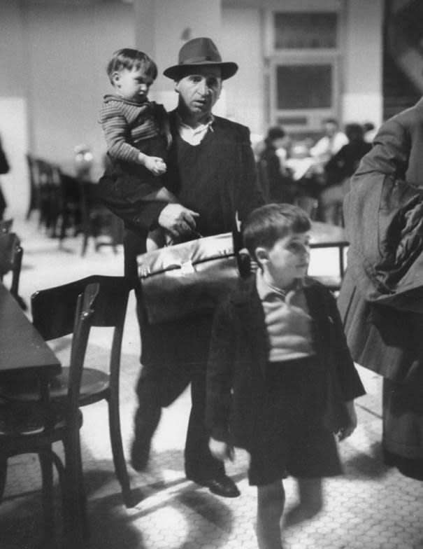 Caption from LIFE. "Antonio Magnani copes with his children and fat briefcase holding his entry papers." Ellis Island, 1950. (Alfred Eisenstaedt—Time & Life Pictures/Getty Images) <br> <br> <a href="http://life.time.com/history/ellis-island-rare-photos-from-the-gateway-to-a-new-world-1950/#1" rel="nofollow noopener" target="_blank" data-ylk="slk:Click here to see the full collection at LIFE.com;elm:context_link;itc:0;sec:content-canvas" class="link ">Click here to see the full collection at LIFE.com</a>