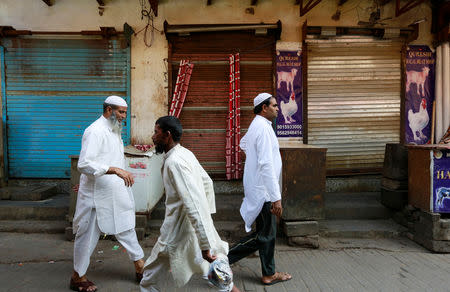 People walk past in front of closed meat shops in Gurugram, India, October 12, 2018. REUTERS/Adnan Abidi