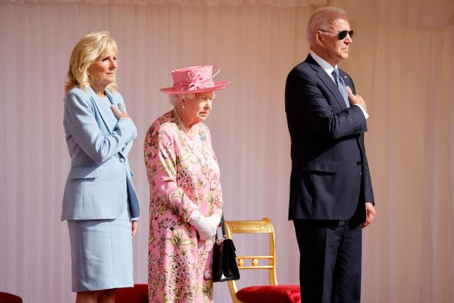 US President Joe Biden (R) and US First Lady Jill Biden (L) stand beside Britain&#39;s Queen Elizabeth II as a Guard of Honour formed of The Queen&#39;s Company First Battalion Grenadier Guards give a Royal Salute during the US National Athem at Windsor Castle in Windsor, west of London, on June 13, 2021. - US president Biden will visit Windsor Castle late Sunday, where he and First Lady Jill Biden will take tea with the queen. (Photo by Tolga Akmen / AFP) (Photo by TOLGA AKMEN/AFP via Getty Images)