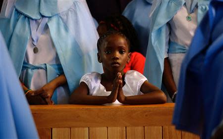 A girl prays during a service for former South African President Nelson Mandela, in the Regina Mundi Church in Soweto December 8, 2013. South African anti-apartheid hero Mandela died aged 95 at his Johannesburg home on December 5 after a prolonged lung infection. REUTERS/Kevin Coombs