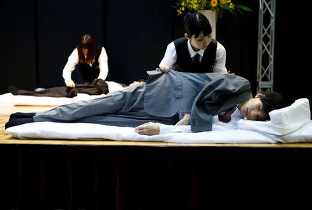 Funeral undertakers dress models during an encoffinment competition at Life Ending Industry EXPO 2017 in Tokyo, Japan August 24, 2017. REUTERS/Kim Kyung-Hoon