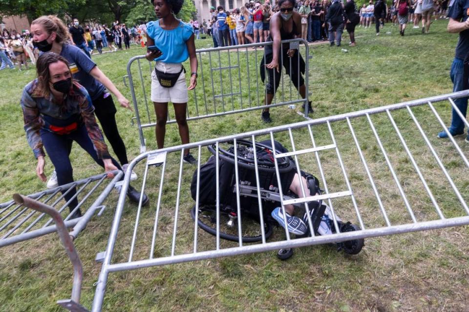 A Pro-Palestinian demonstrator is knocked from a wheelchair as demonstrators clash with police after replacing an American flag with a Palestinian flag Tuesday, April 30, 2024 at UNC-Chapel Hill. Police removed a “Gaza solidarity encampment” earlier Tuesday morning.