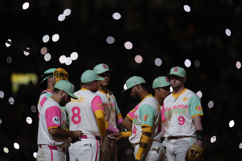 Members of the San Diego Padres wait on the mound during a pitching change in the ninth inning of a baseball game against the Arizona Diamondbacks, Friday, July 5, 2024, in San Diego. (AP Photo/Gregory Bull)