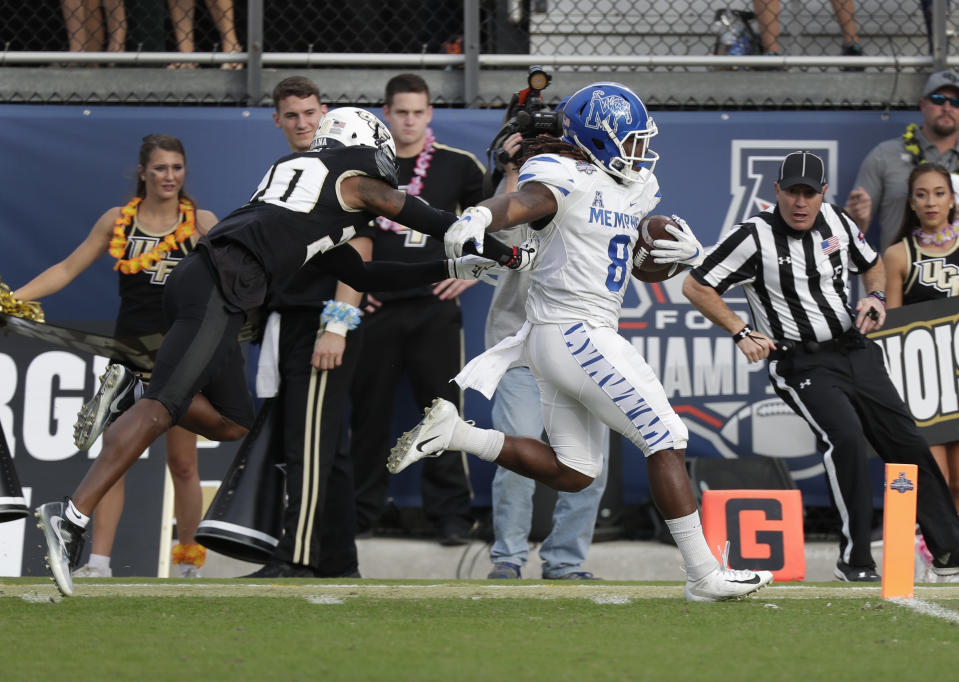 Memphis running back Darrell Henderson (8) runs for a 62-yard touchdown past Central Florida defensive back Brandon Moore, left, during the first half of the American Athletic Conference championship NCAA college football game, Saturday, Dec. 1, 2018, in Orlando, Fla. (AP Photo/John Raoux)