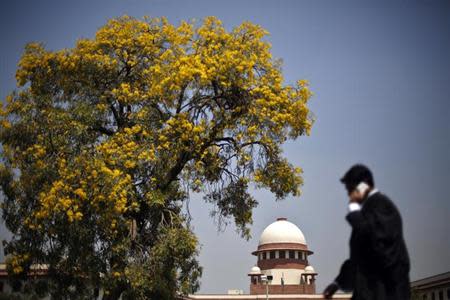 A lawyer speaks on his mobile phone as he walks past the Supreme Court in New Delhi April 1, 2013. REUTERS/Adnan Abidi/Files