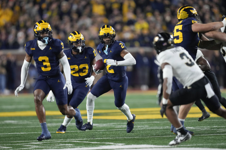 Michigan defensive back Will Johnson (2) returns an interception against Purdue in the first half of an NCAA college football game in Ann Arbor, Mich., Saturday, Nov. 4, 2023. (AP Photo/Paul Sancya)