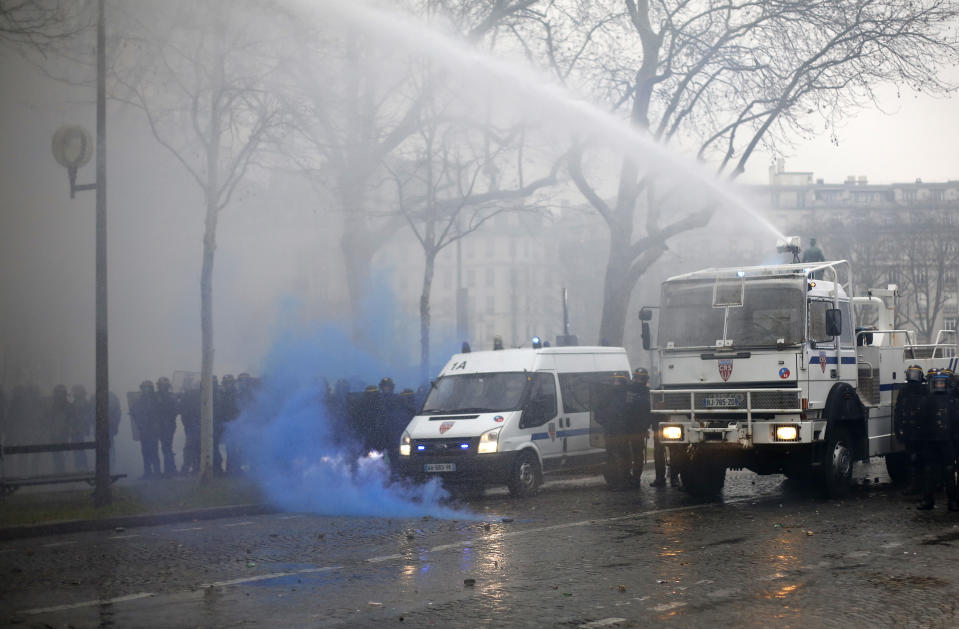 Police forces use a water cannon to disperse a yellow vest march Saturday, Jan. 19, 2019 in Paris. Thousands of yellow vest protesters rallied Saturday in several French cities for a 10th consecutive weekend, despite a national debate launched this week by President Emmanuel Macron aimed at assuaging their anger. (AP Photo/Thibault Camus)