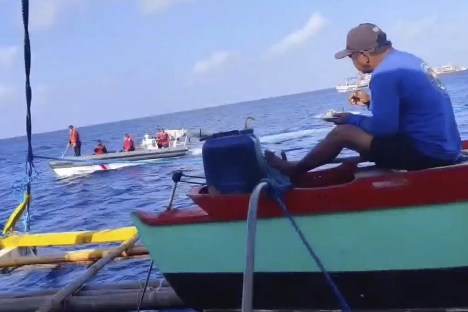 In this photo taken from video provided by Joely Saligan, Chinese coast guard on rubber boats passes by a Philippine fishing boat at the disputed Scarborough Shoal off the northwestern Philippines on Jan. 12, 2023. A Filipino fishing boat captain said Tuesday that he asserted Philippine sovereign rights in a tense confrontation with Chinese authorities in the disputed South China Sea in a new spat that is testing efforts by Beijing and Manila to deescalate tensions in a potential Asian flashpoint. (Joely Saligan via AP)