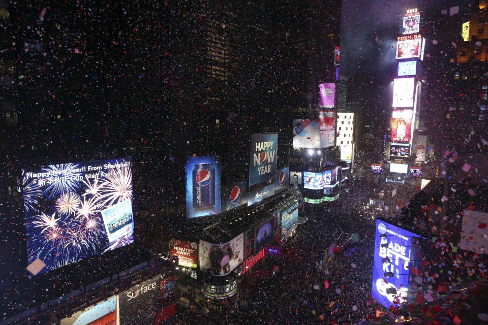 FILE - In this Jan. 1, 2013, file photo, donfetti flies over New York's Times Square after the clock strikes midnight during the New Year's Eve celebration as seen from the Marriott Marquis hotel in New York. As Americans prepare to ring in 2014, they look to the new year with an optimistic eye, according to a new AP-Times Square New Year’s Eve poll, while their ratings of the year gone by are less than glowing. (AP Photo/Mary Altaffer, File)