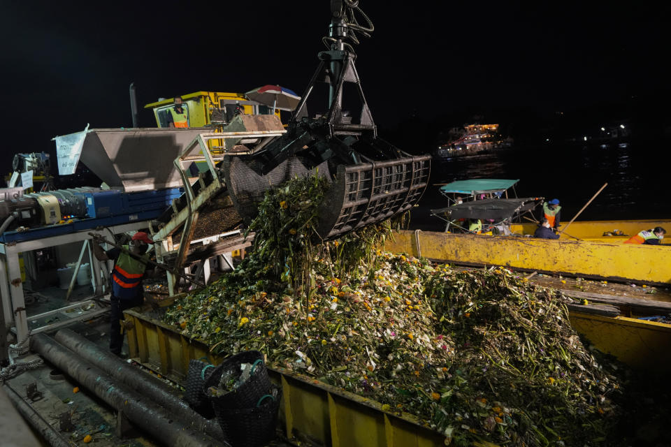 Workers collect small floating krathong from Chao Phraya River during Loy Krathong festival in Bangkok, Thailand, Friday, Nov. 19, 2021. As Thais flocked to waterways Friday to release small floats adorned with flowers and candles in an annual festival honoring the goddess of rivers, they also pile trash that clogs drains and canals and pollutes the country's rivers. (AP Photo/Sakchai Lalit)