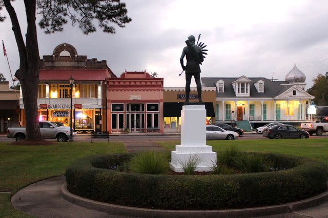 <p>Patrick Donovan/Getty Images</p> Sunset view of bronze statue of Attakapa Indian (1961, unknown artist) and buildings on the public town square in the Acadian (Cajun) town of Saint Martinville, Saint Martin Parish, Louisiana.