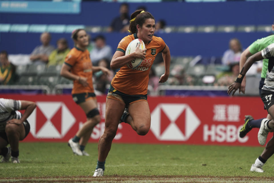 Australia's Charlotte Caslick runs to score a try against Fiji during the second day of the Hong Kong Sevens rugby tournament in Hong Kong, Saturday, April 1, 2023. (AP Photo/Anthony Kwan)